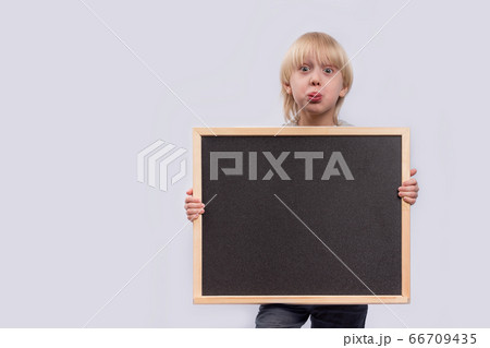 Surprised boy holding blackboard. Black copy 66709435
