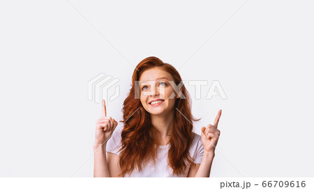 Millennial Girl Pointing Fingers Upward Posing In Studio, Panorama 66709616