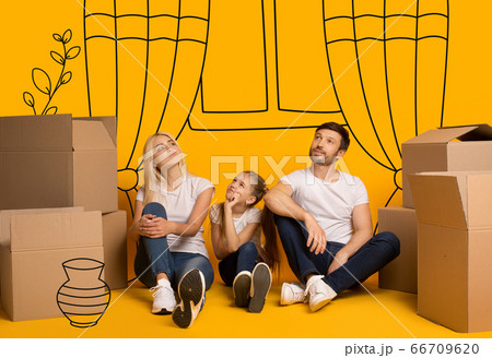Family with child dreaming about new furnished apartment on orange background with doodle drawings Family with child dreaming about new furnished apartment on orange background with doodle drawings 66709620