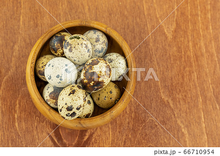 wooden bowl full of quail eggs on a dark 66710954