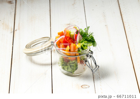 Fresh garden healthy vegetables in a glass jar Fresh garden healthy vegetables in a glass jar 66711011