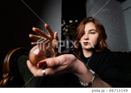 Woman in black suit holding crystal ball Woman in black suit holding crystal ball 66713149