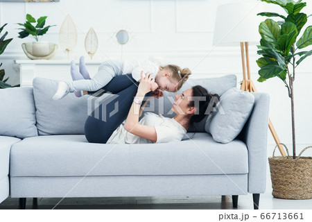 mom and her daughter lying on the couch in the living room. 66713661