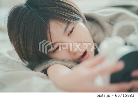めざまし時計を止める30代女性 めざまし時計を止める30代女性 66715932
