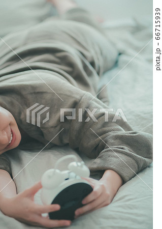 めざまし時計を止める30代女性 66715939