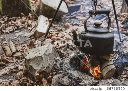 High angle close up of kettle over camp fire in a forest. 66716590