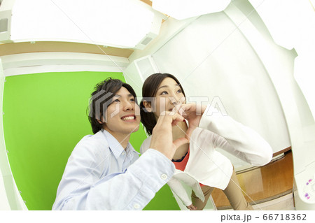 プリクラを撮る男女の写真素材