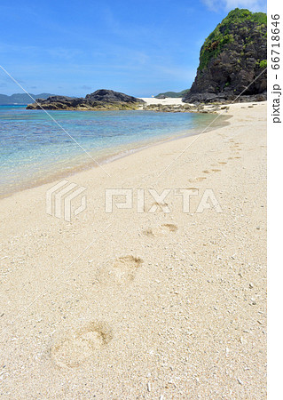 足跡が残っている白い砂浜ときれいな海 沖縄県の写真素材