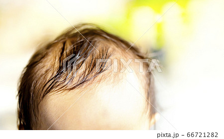 赤ちゃんの頭 前髪 または前頭部 そして汗で濡れた髪の写真素材