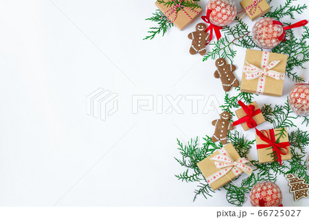 Christmas holiday background with gift boxes, gingerbreads, fir tree branches and decorations on white table. Flat lay and copy space top view 66725027
