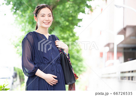 カメラ目線で微笑むワンピース姿の働く妊婦 66726535