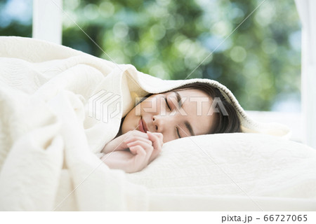 ベットで眠る若い女性 66727065