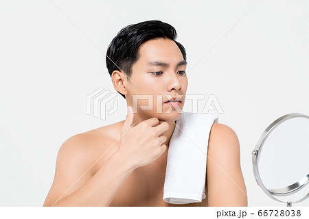 Shirtless young handsome Asian man looking at his face 66728038