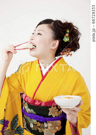 お餅を食べる振袖姿の女性 66728355