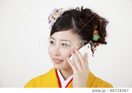 電話する振袖女性 66728367