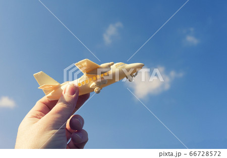 close up photo of male hand holding toy airplane 66728572