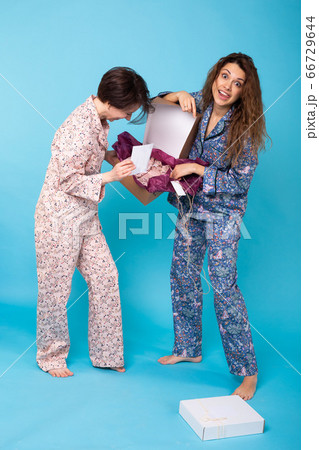 Online shopping, delivery and fashion concept - Women opening online clothing purchase. Online shopping, delivery and fashion concept - Women opening online clothing purchase. 66729644
