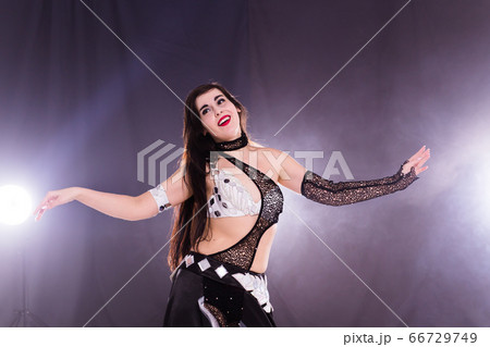 Spirituality dance. Beautiful sexy woman with luxury glossy eastern make-up dancing tribal fusion. Belly dance. 66729749