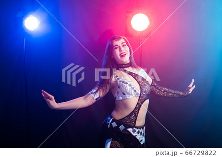 Young woman dancing in Tribal Fusion style. Belly dance on the stage. Young woman dancing in Tribal Fusion style. Belly dance on the stage. 66729822