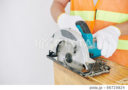 Builder cutting wooden plank Builder cutting wooden plank 66729824