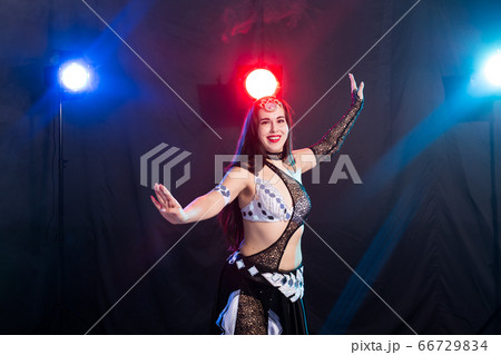 Young woman dancing in Tribal Fusion style. Belly dance on the stage. Young woman dancing in Tribal Fusion style. Belly dance on the stage. 66729834