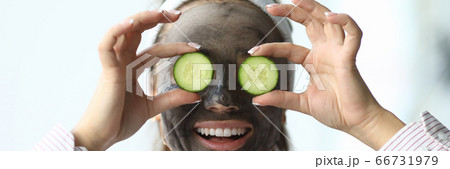 Girl with cosmetic mask on face cucumbers in eyes Girl with cosmetic mask on face cucumbers in eyes 66731979
