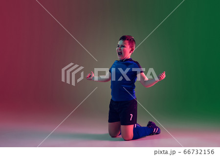 Teen male football or soccer player, boy on gradient background in neon light - motion, action, activity concept 66732156