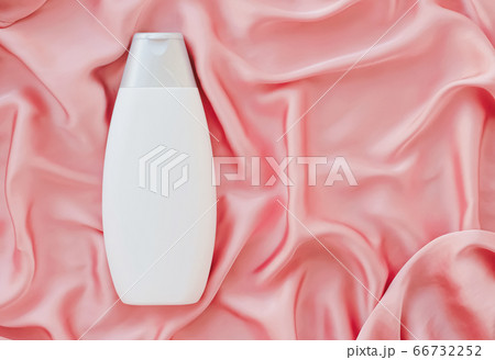 Blank label cosmetic container bottle as product mockup on pink silk background Blank label cosmetic container bottle as product mockup on pink silk background 66732252