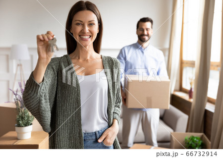 Smiling young woman satisfied customer showing keys, moving day Smiling young woman satisfied customer showing keys, moving day 66732914