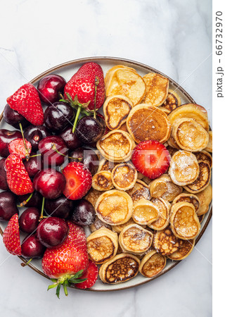 Tiny cereal pancakes and strawberries Tiny cereal pancakes and strawberries 66732970