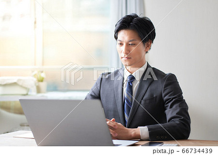PCの画面を見つめるスーツの男性 66734439