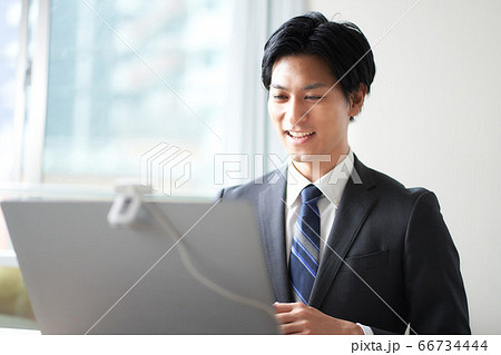 ビデオ通話をするスーツの男性 66734444