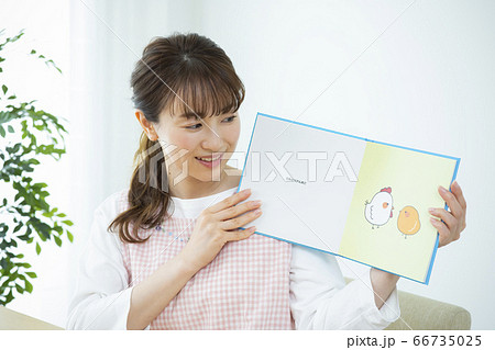 読み聞かせをする保育士（絵本はピクスタ撮影のために作成したダミーです） 66735025