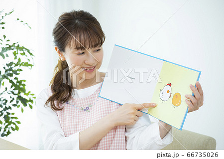 読み聞かせをする保育士（絵本はピクスタ撮影のために作成したダミーです） 66735026