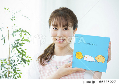 読み聞かせをする保育士（絵本はピクスタ撮影のために作成したダミーです） 66735027