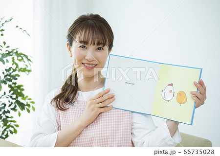 読み聞かせをする保育士（絵本はピクスタ撮影のために作成したダミーです） 66735028