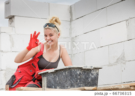 Woman working on home construction site Woman working on home construction site 66736315