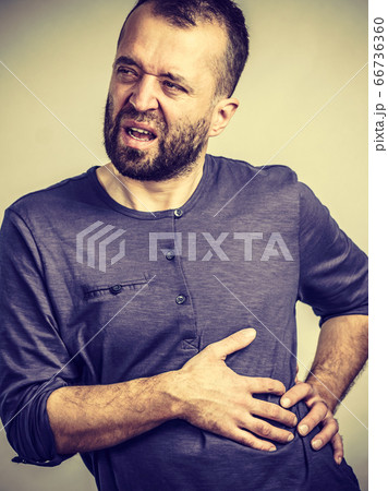Man having stomach or ribs pain ache. Man having stomach or ribs pain ache. 66736360