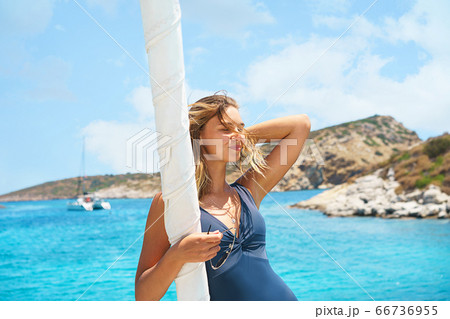 Happy young woman feels happy on the luxury sail boat yacht catamaran in turquoise sea. Happy young woman feels happy on the luxury sail boat yacht catamaran in turquoise sea. 66736955