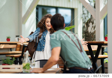 Happy couple greeting outdoors on terrace restaurant, end of lockdown. Happy couple greeting outdoors on terrace restaurant, end of lockdown. 66737009