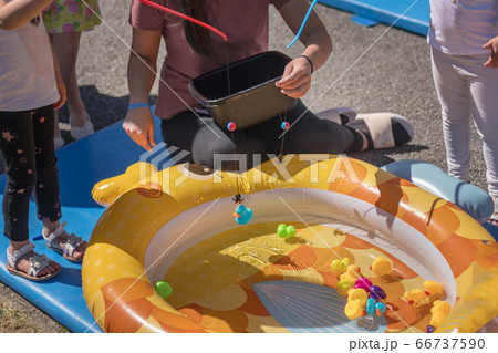 Girls catch rubber ducks with fishing rod 66737590