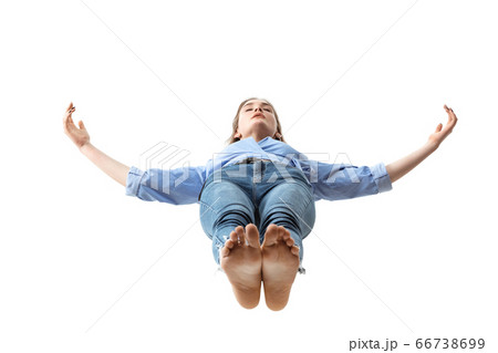 Mid-air beauty. Full length studio shot of attractive young woman hovering in air and keeping eyes closed 66738699