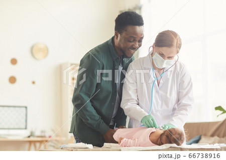 Nurse Examining Baby at Home 66738916