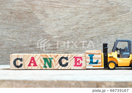 Toy forklift hold letter block L to complete word cancel on wood background Toy forklift hold letter block L to complete word cancel on wood background 66739167
