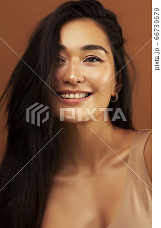 young pretty asian woman cheerful smiling posing on warm brown background, lifestyle people concept 66739679