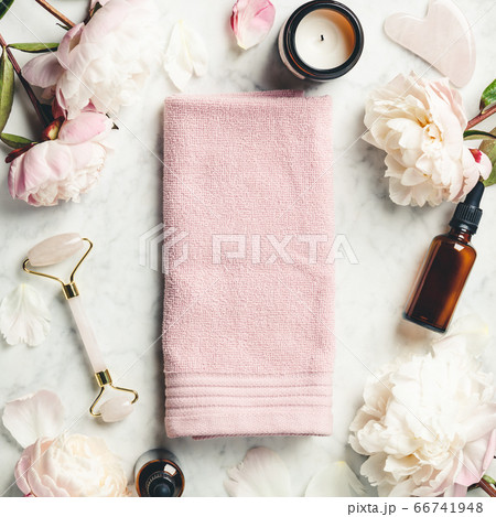Beauty Products. Facial Roller, essential oils, towel and beautiful peonies on white marble background 66741948