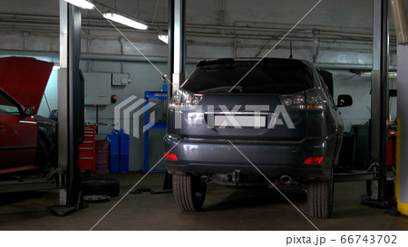 Two cars with an opened hood in car repair service. 66743702