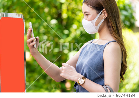 Asian woman scaning online queue for restaurant. 66744134