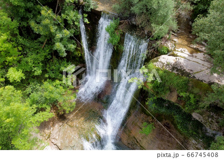 Aerial view of an Idyllic rain forest waterfall, stream flowing in the lush green forest. 66745408
