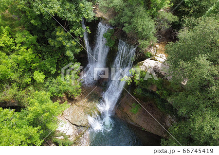Aerial view of an Idyllic rain forest waterfall, stream flowing in the lush green forest. Aerial view of an Idyllic rain forest waterfall, stream flowing in the lush green forest. 66745419